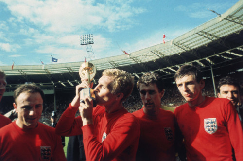 England captain Bobby Moore kissing the Jules Rimet trophy as the team celebrate winning the 1966 Wo